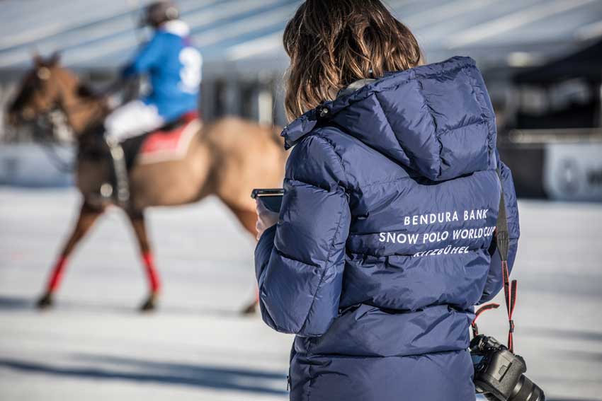 Frau mit blauer Jacke mit der Aufschrift Snow Poloo Kitzbühel