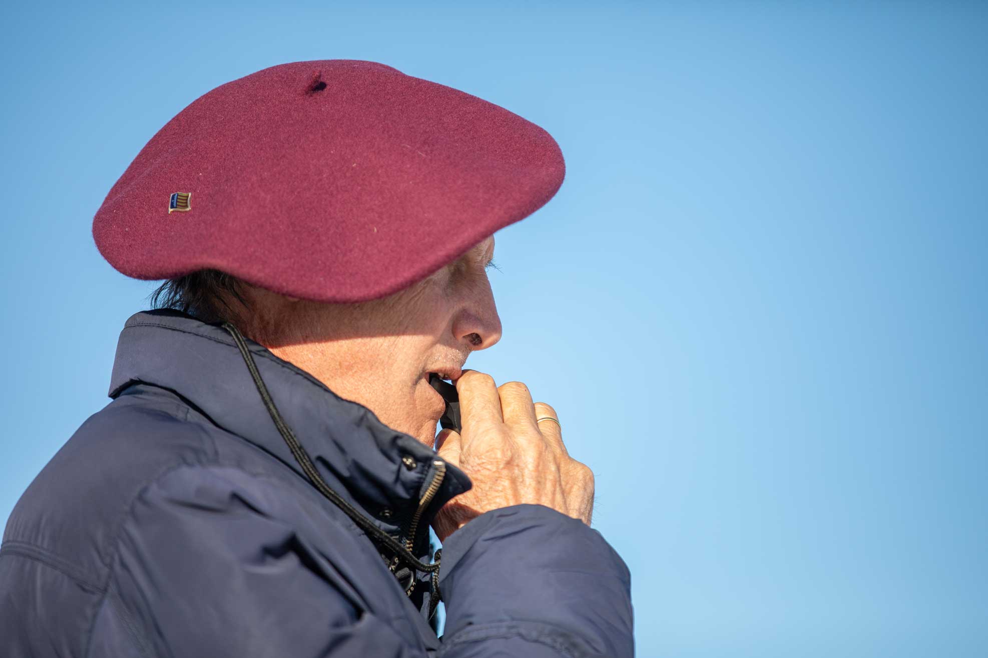 Schiedsrichter Mann mit roter Mütze und Pfeife beim Snow Polo