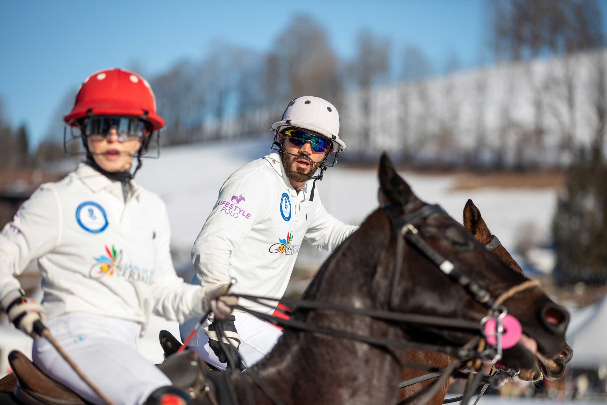 Snow Polo auf dem Pferd Mann und Frau mit weißem Shirt