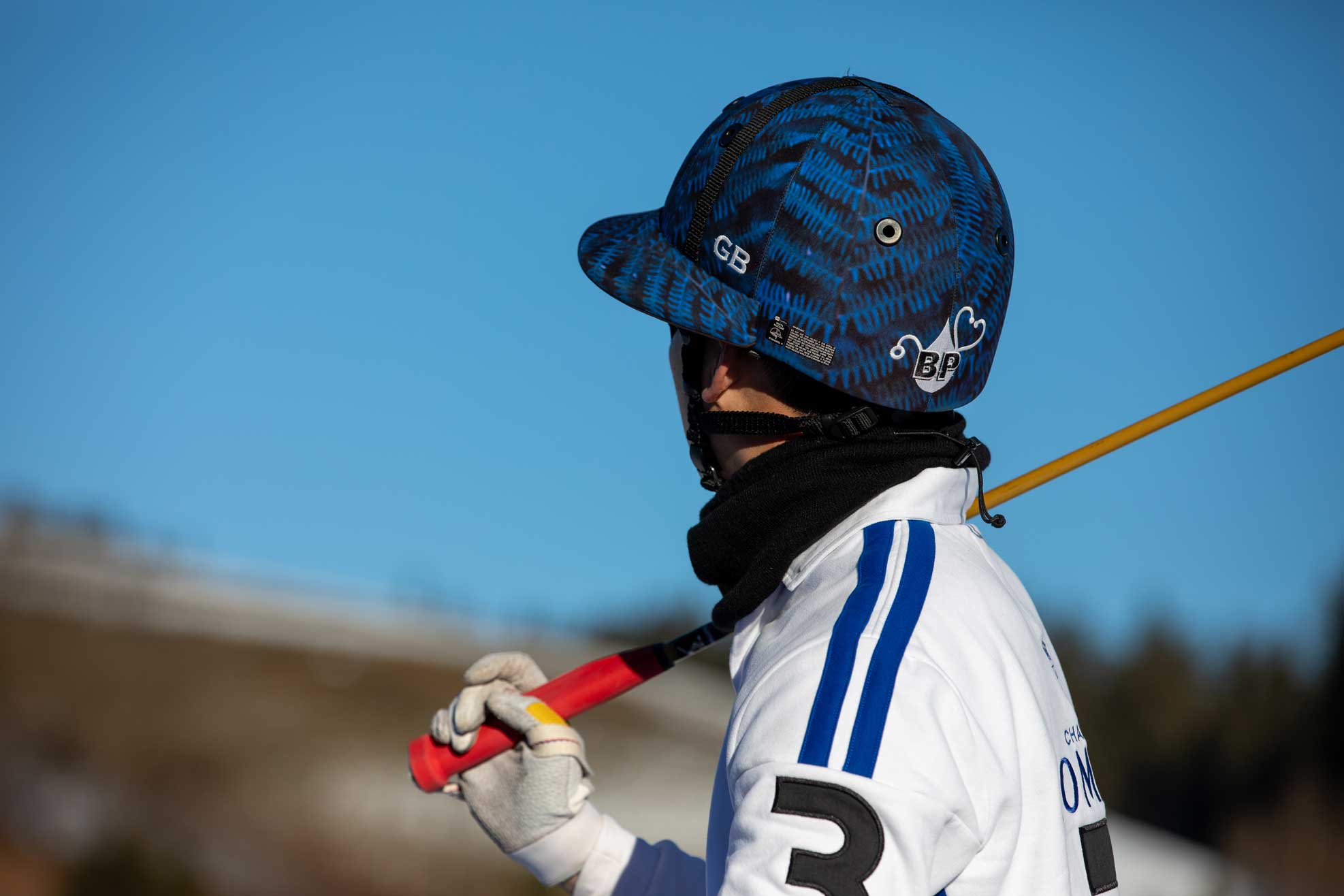 Snow Polo Spieler Headshot mit weißem Trikot und blauem Helm und Schläger